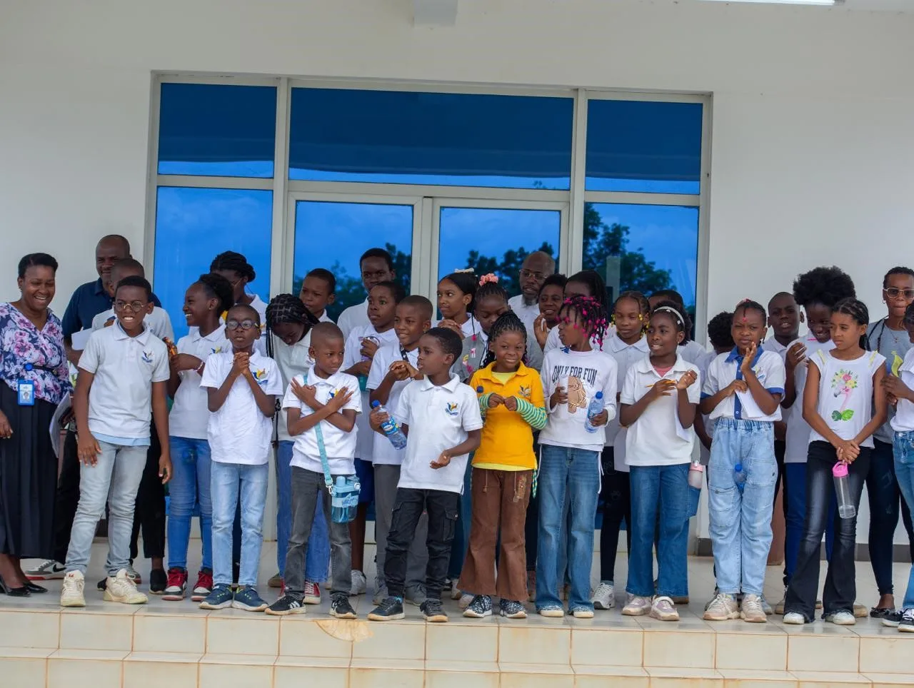 Grupo de alunos do Colégio Cultus com fardas brancas, sorridentes durante uma actividade escolar